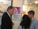 Zwei Zahnärzte schauen den Anwenderfilm am Messestand